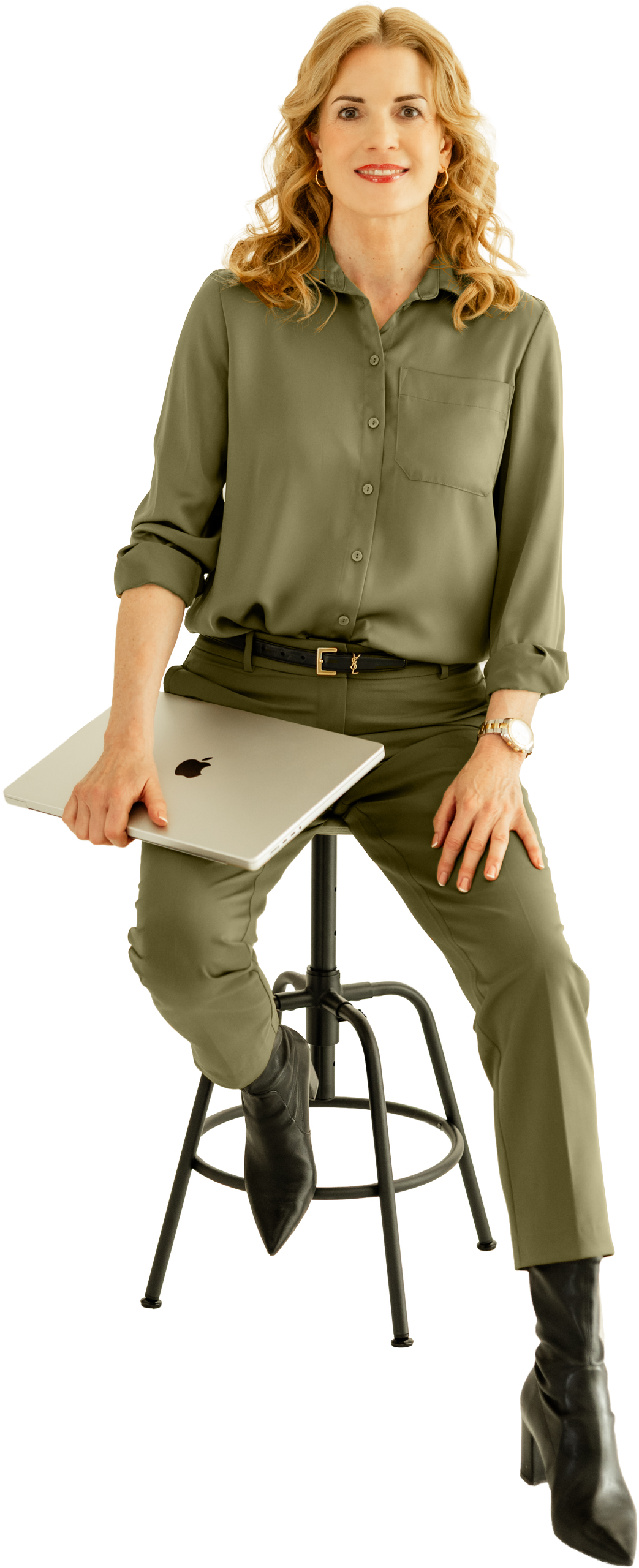 Ulrike Hostehradsky im KREATIVSTUDIO München Ulrike Hostehradsky sitzt auf einem Hocker und hält ein MacBook Pro in der Hand im KREATIVSTUDIO München
